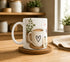 Taza "Necesito Energía para Aguantar el Día" de cerámica blanca con diseño divertido para amantes del café y desayuno.